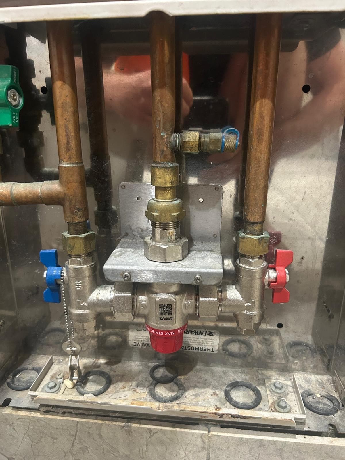 Thermostatic mixing valve (TMV) on copper pipes, with red and blue isolation valves