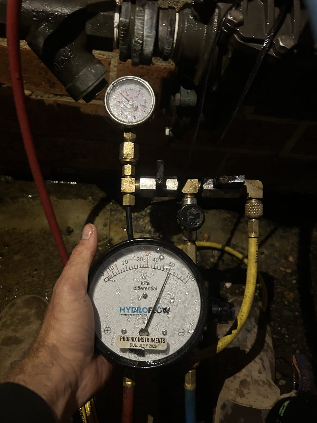 Differential pressure gauge used for a backflow test, with the test hoses connected
