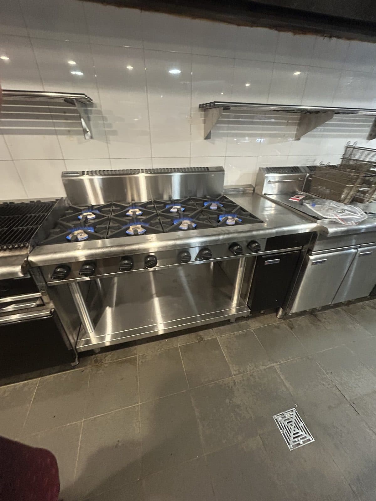 Commercial kitchen line with the gas cooktop running